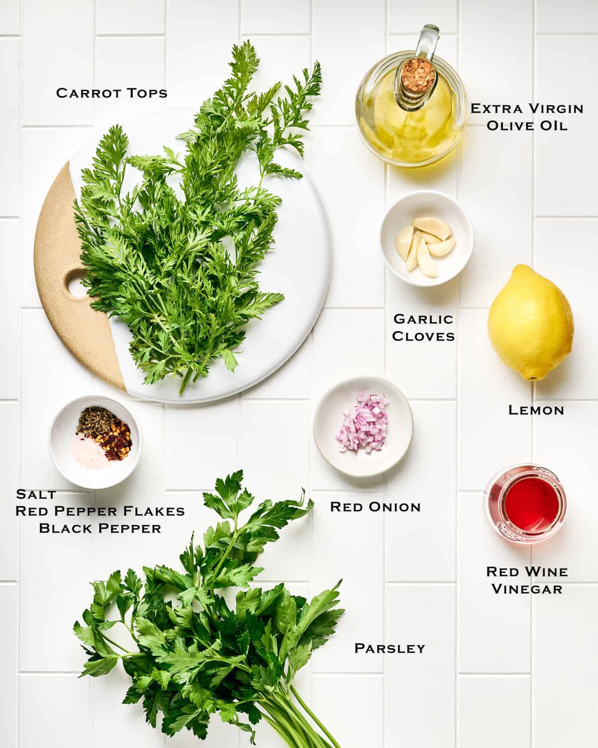 Ingredients to make Carrot Top Chimichurri on a tile surface.