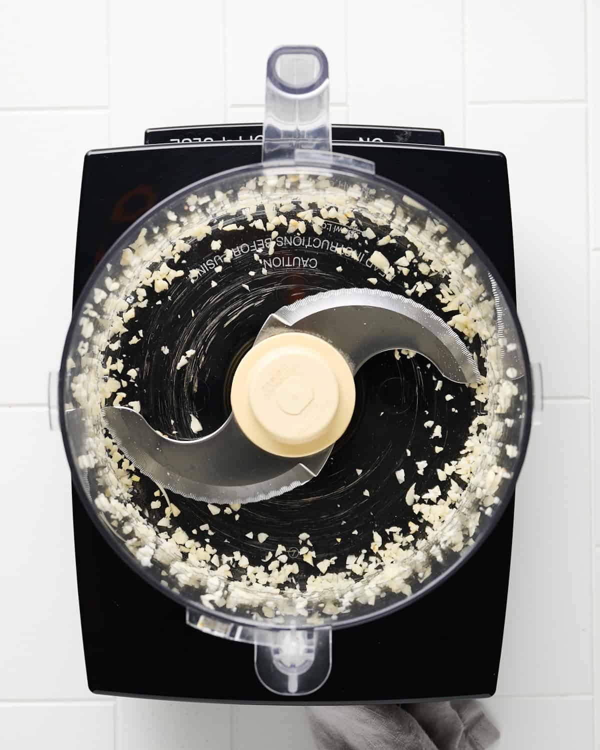 Minced garlic in a food processor bowl.