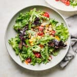 Bowl of quinoa chickpea salad with lemon tahini dressing.