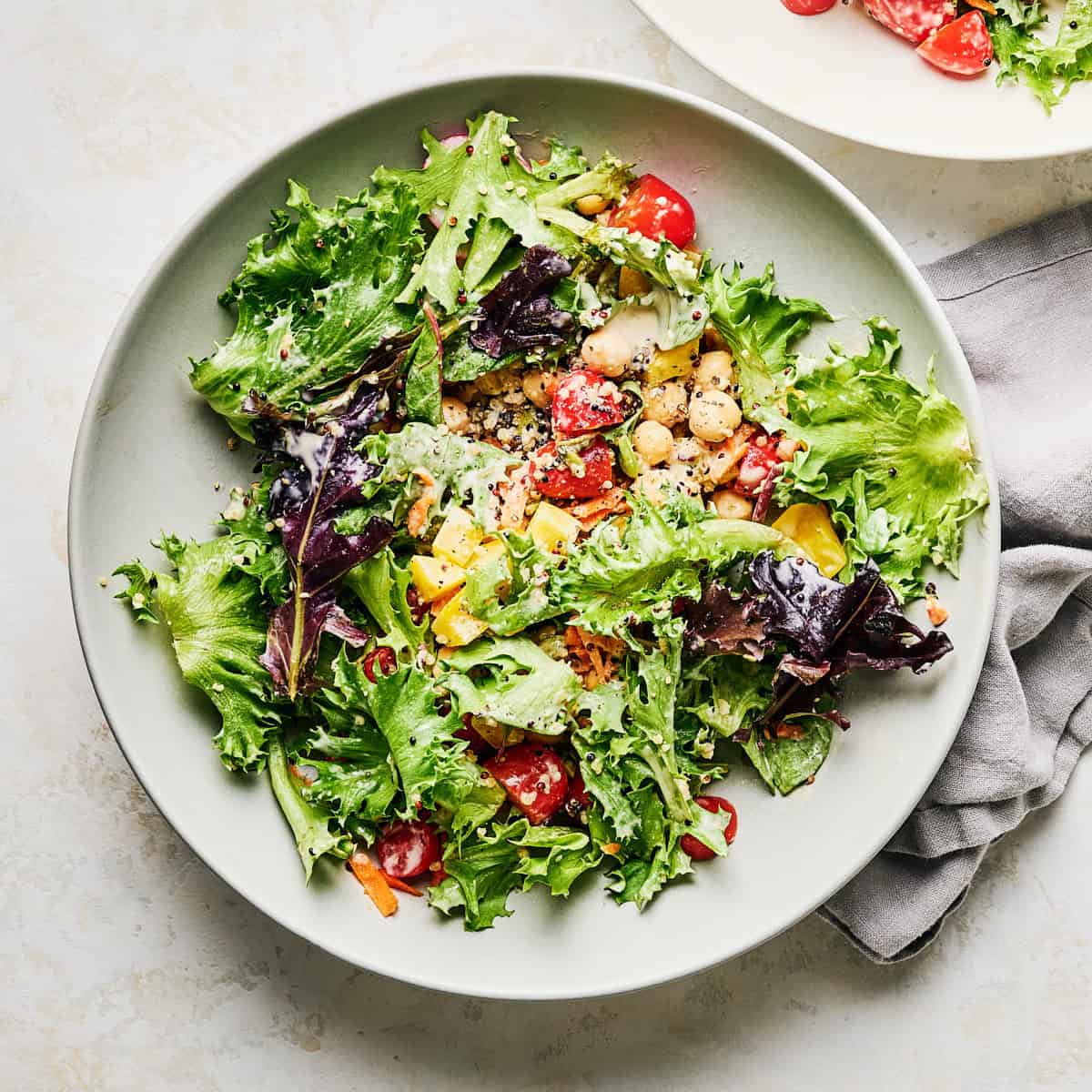 Bowl of quinoa chickpea salad with lemon tahini dressing.