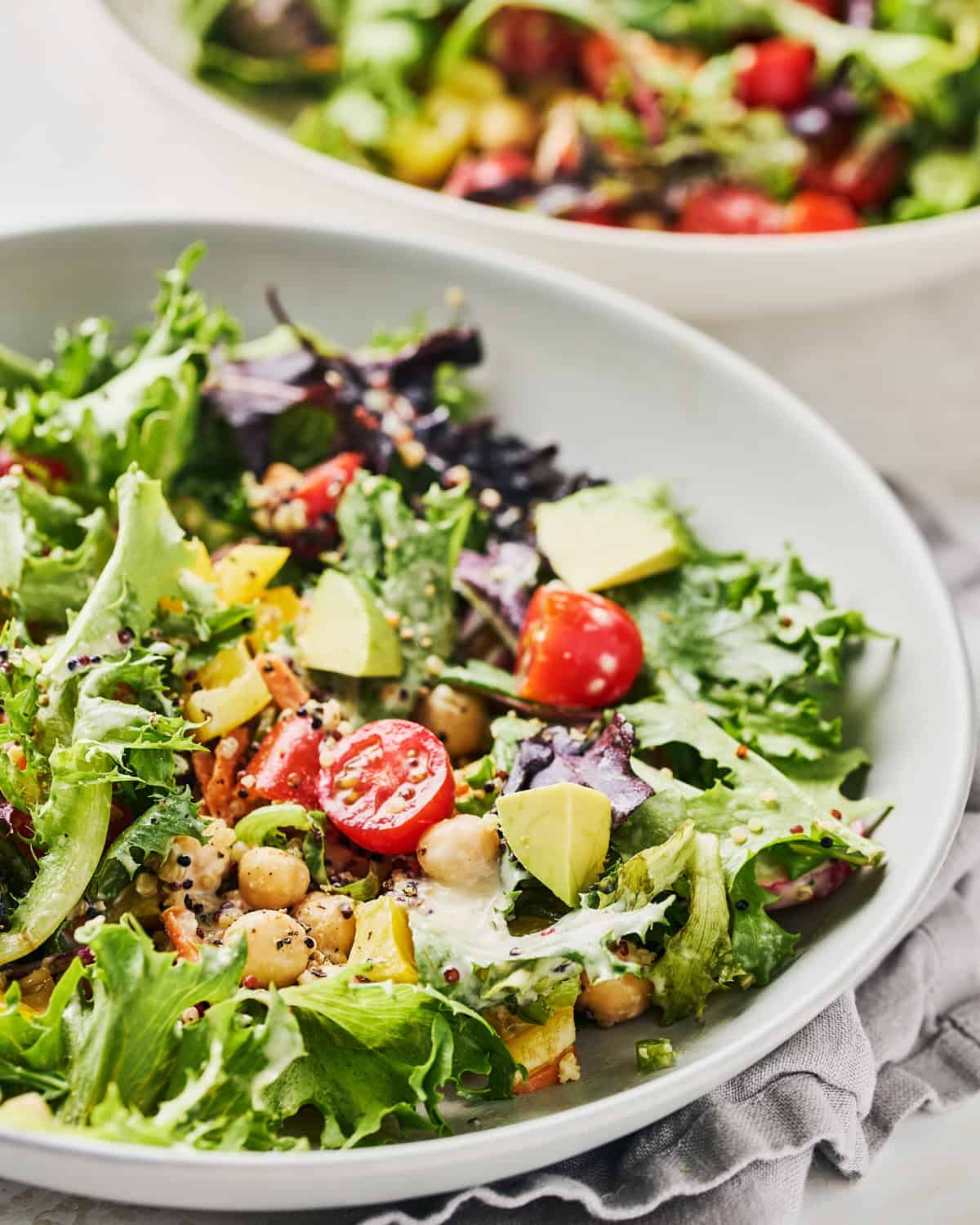 Bowl of quinoa chickpea salad with lemon tahini dressing.