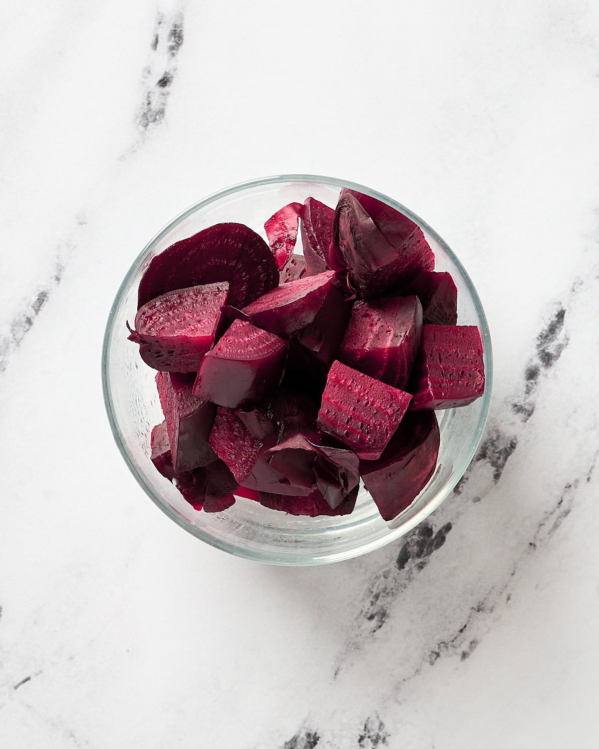 Cooked and chopped beets in a small glass bowl.