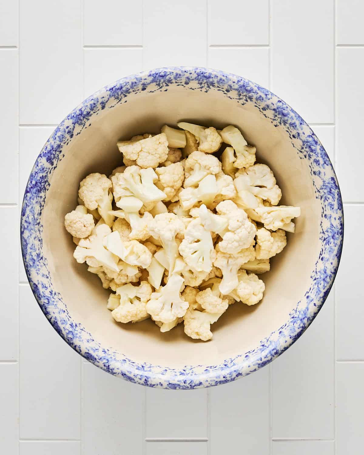 Raw cauliflower florets in a large bowl.