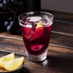 Summer red wine spritzer with slice of lemon in a glass.