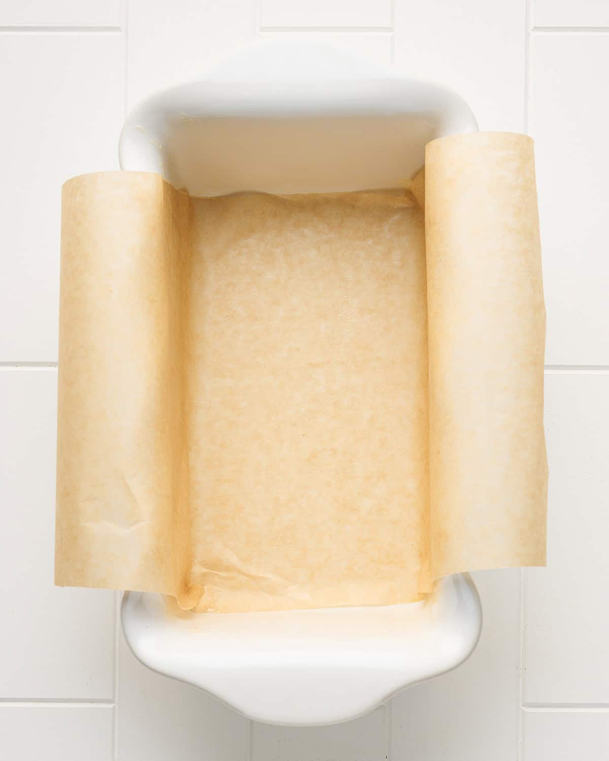 Buttered loaf pan size baking dish with parchment paper.