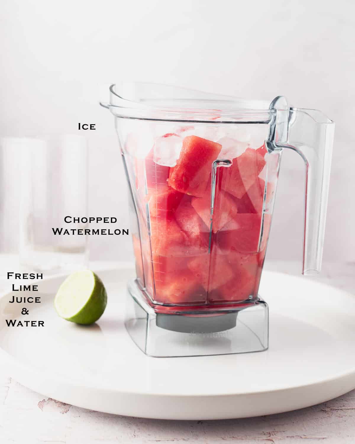 Ingredients to make watermelon water in a plastic blender container.