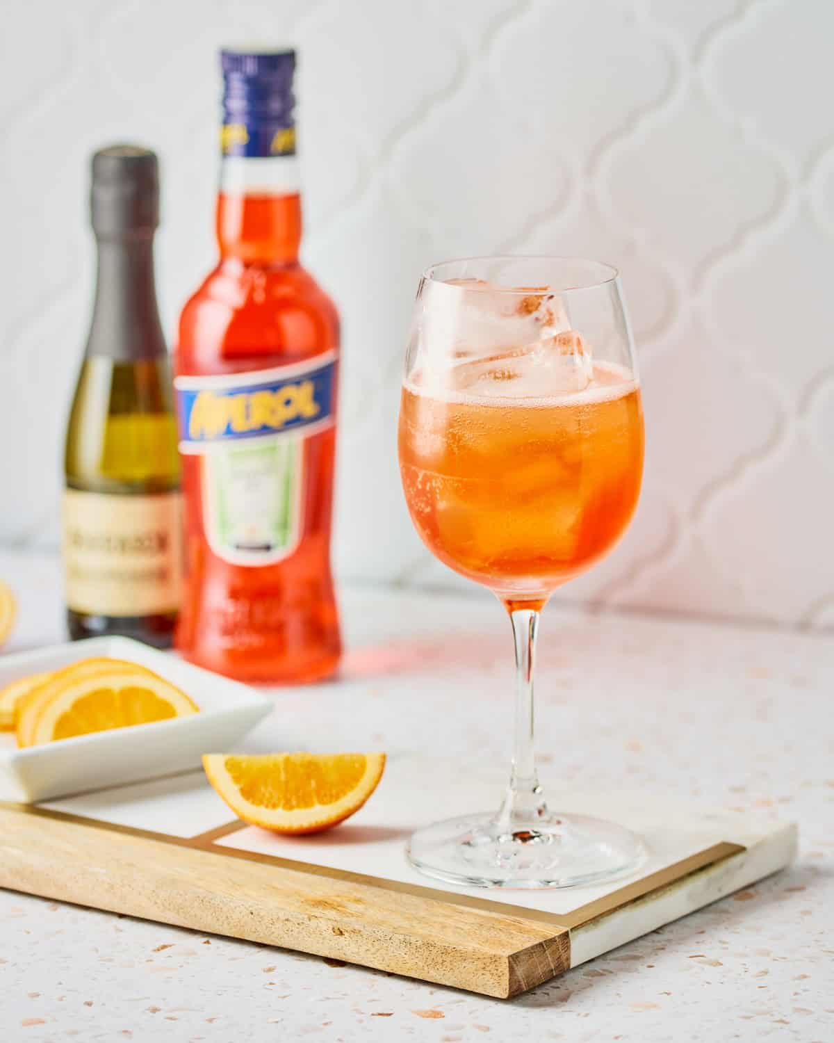 Added club soda to the aperol, Prosecco, and ice in a white wine glass.