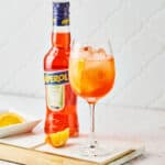 A white wine glass filled with 3-2-1 Aperol Spritz recipe.