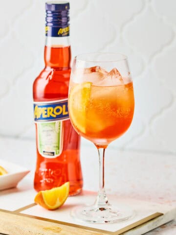 A white wine glass filled with 3-2-1 Aperol Spritz recipe.