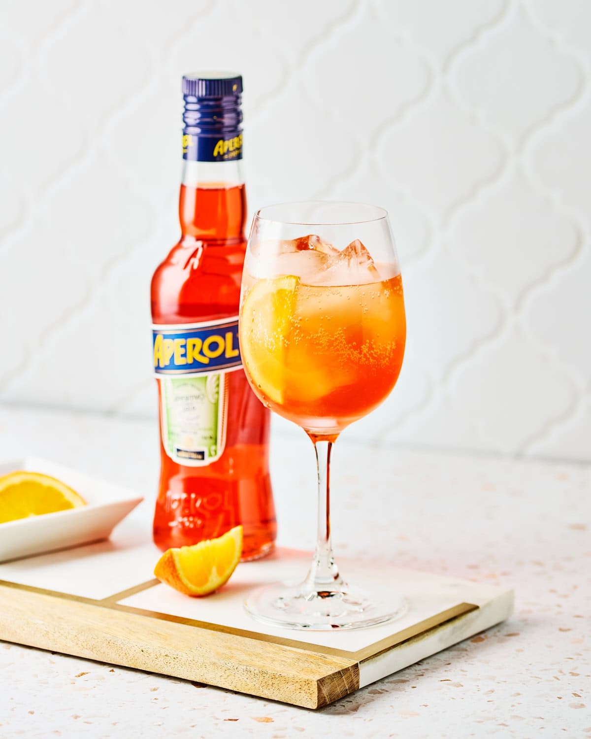 A white wine glass filled with 3-2-1 Aperol Spritz recipe.