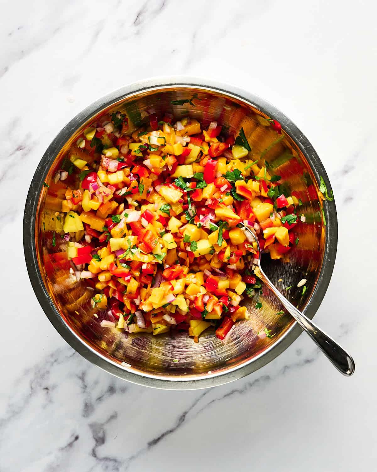 Chopped ingredients in bowl to make mango habanero salsa.