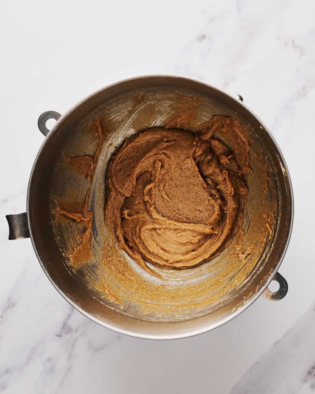 Mixing bowl with vegan oatmeal raisin cookie batter before raisins and oatmeal added.
