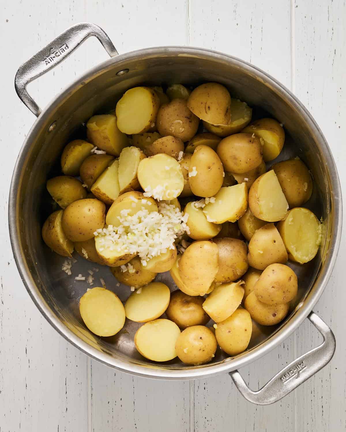 Mixing cooked Yukon gold potatoes with chopped green onion.