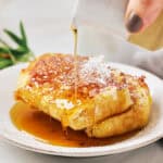 Pouring maple syrup on plant-based JUST Egg French Toast with Grand Marnier.
