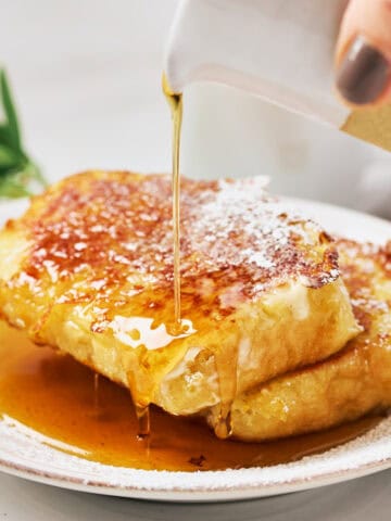 Pouring maple syrup on plant-based JUST Egg French Toast with Grand Marnier.