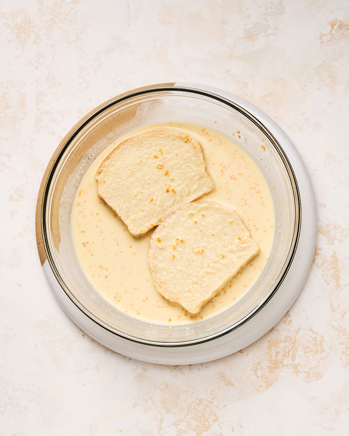 Dipping two slices of vegan brioche in JUST Egg custard in a bowl.