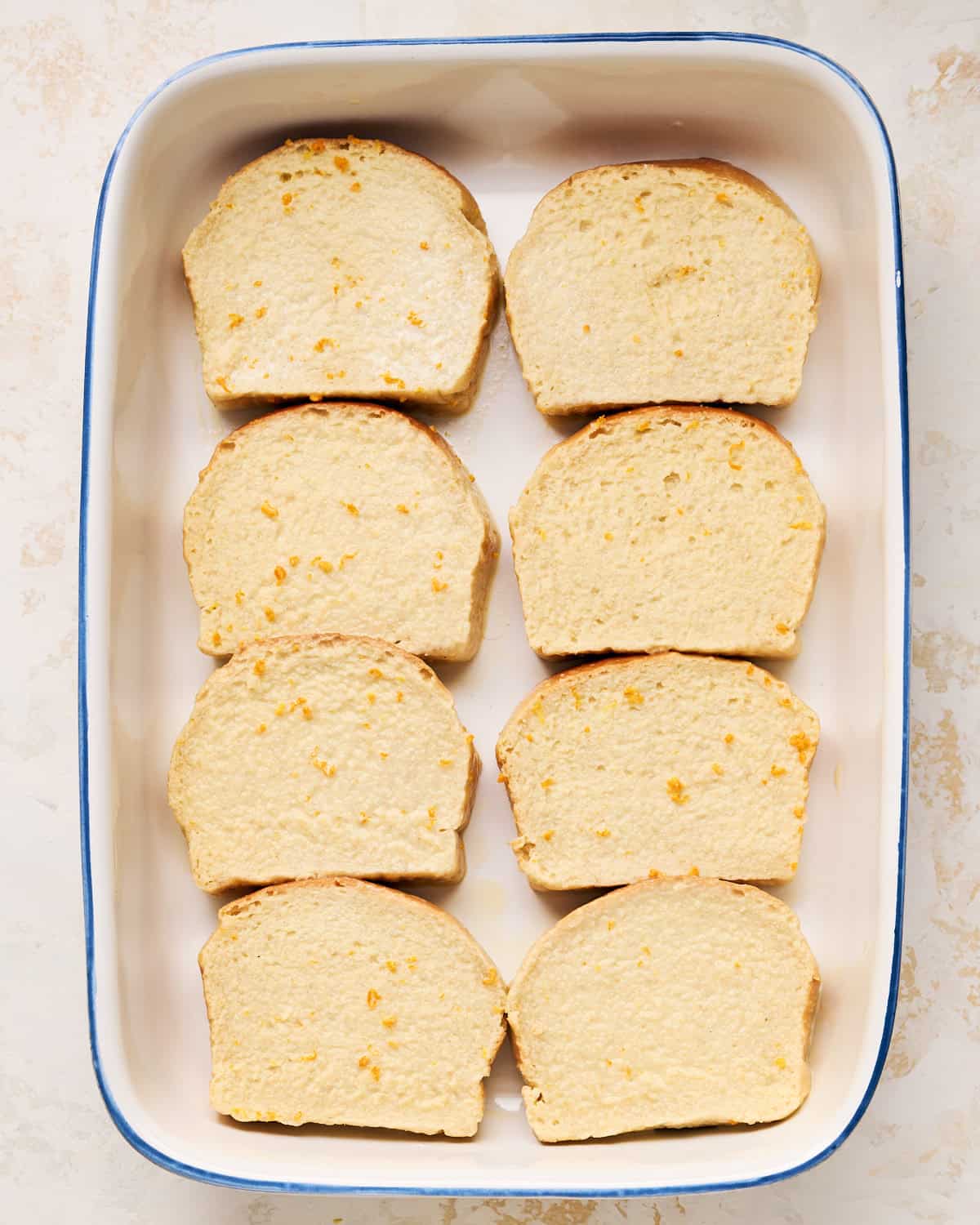 Slices of vegan brioche dipped in JUST Egg custard in a baking dish.