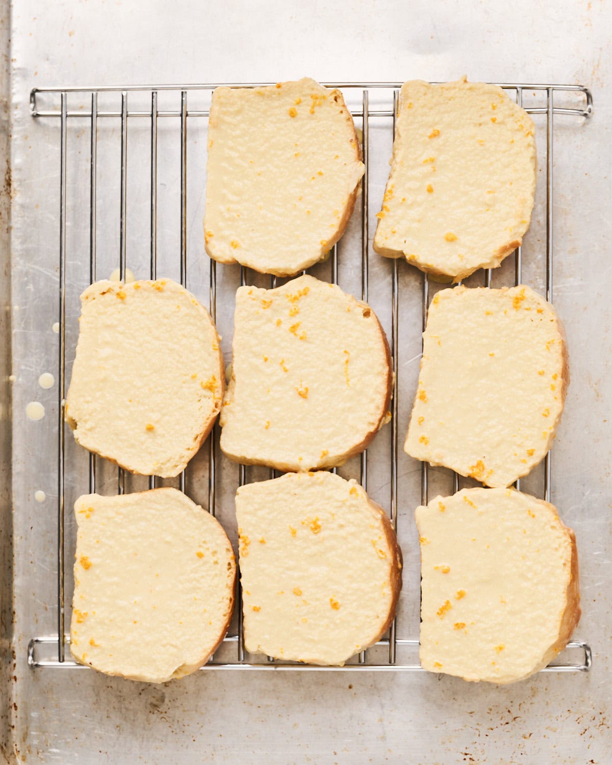 Slices of brioche draining excess custard mixture before being cooked in skillet.
