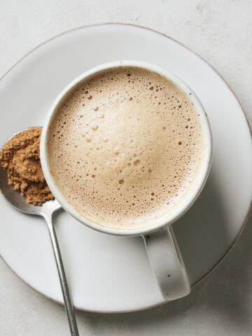 Vegan mushroom latte in a mug with a spoonful of mushroom powder next to it.