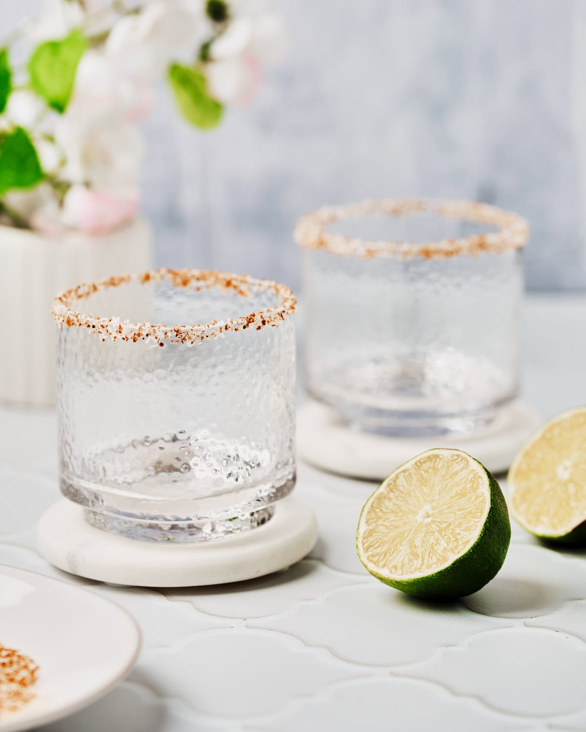 Two glasses rimmed with Tajin and sea salt.