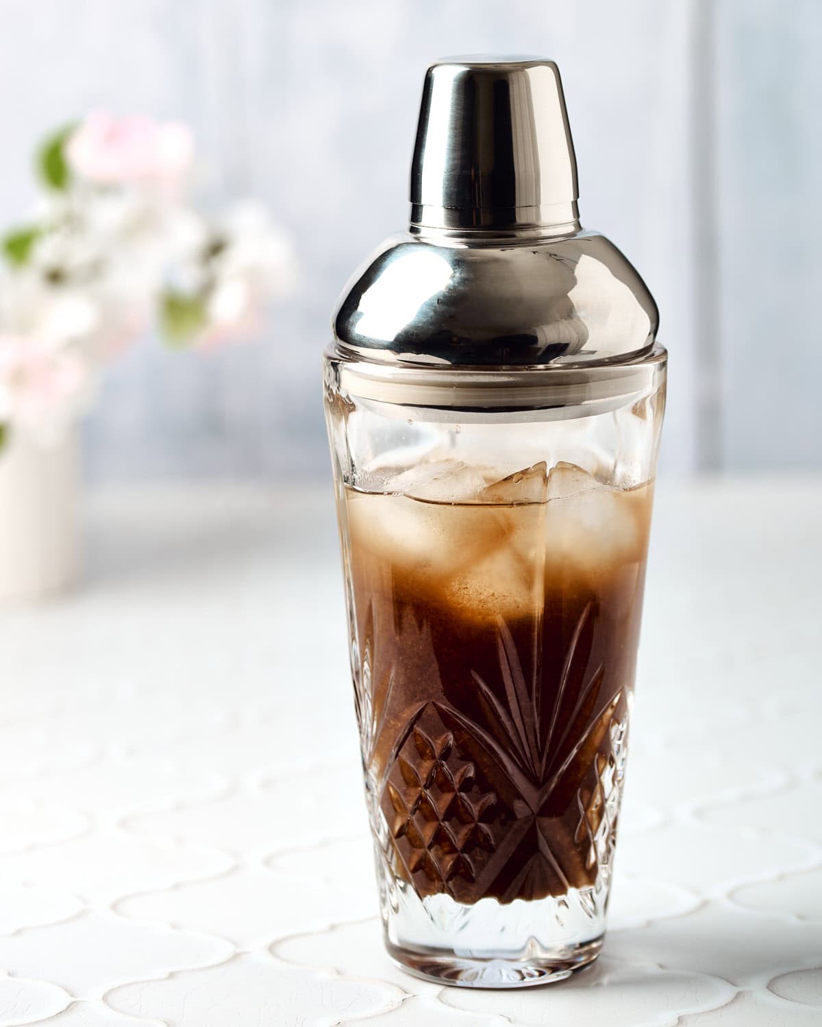 Cocktail shaker filled with ingredients to make a tamarind margarita.
