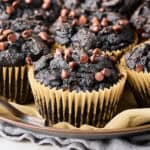 A plate with vegan chocolate sweet potato muffins on parchment paper.