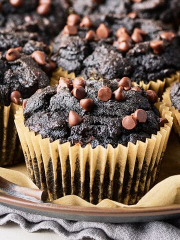 A plate with vegan chocolate sweet potato muffins on parchment paper.