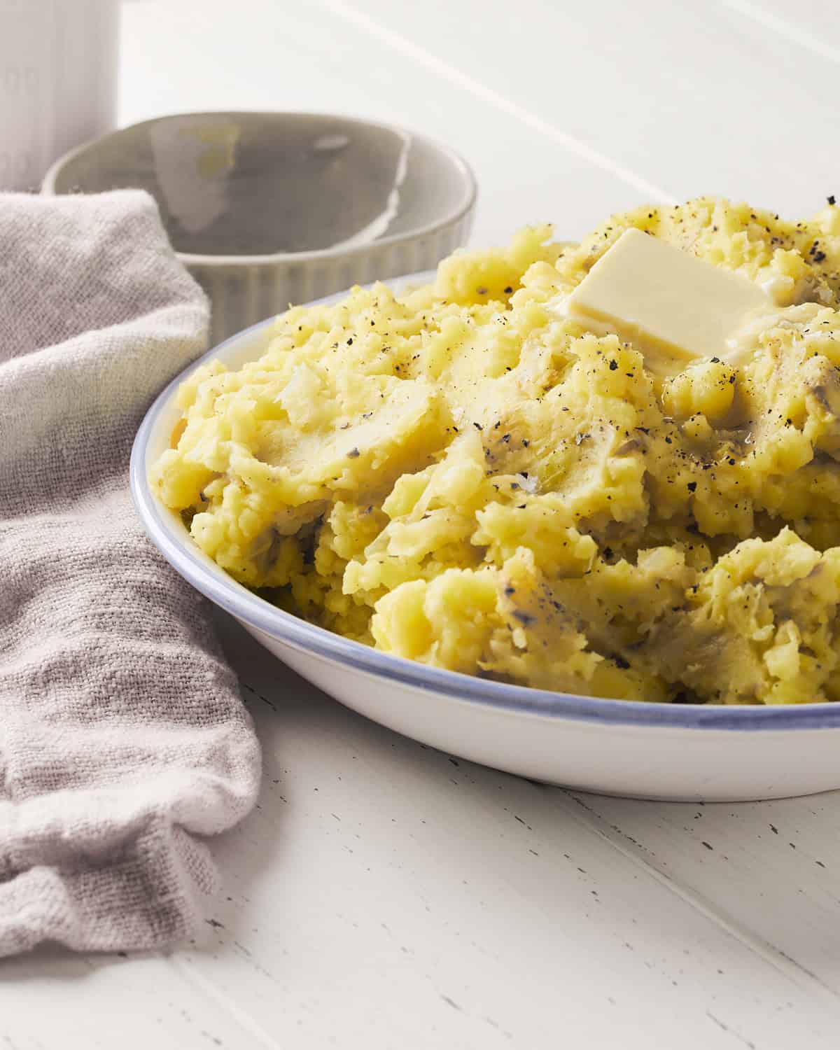 Vegan Irish Colcannon made with cabbage and potatoes in a serving bowl with vegan butter.
