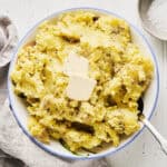 Vegan Irish Colcannon made with cabbage and potatoes in a serving bowl with a spoon.