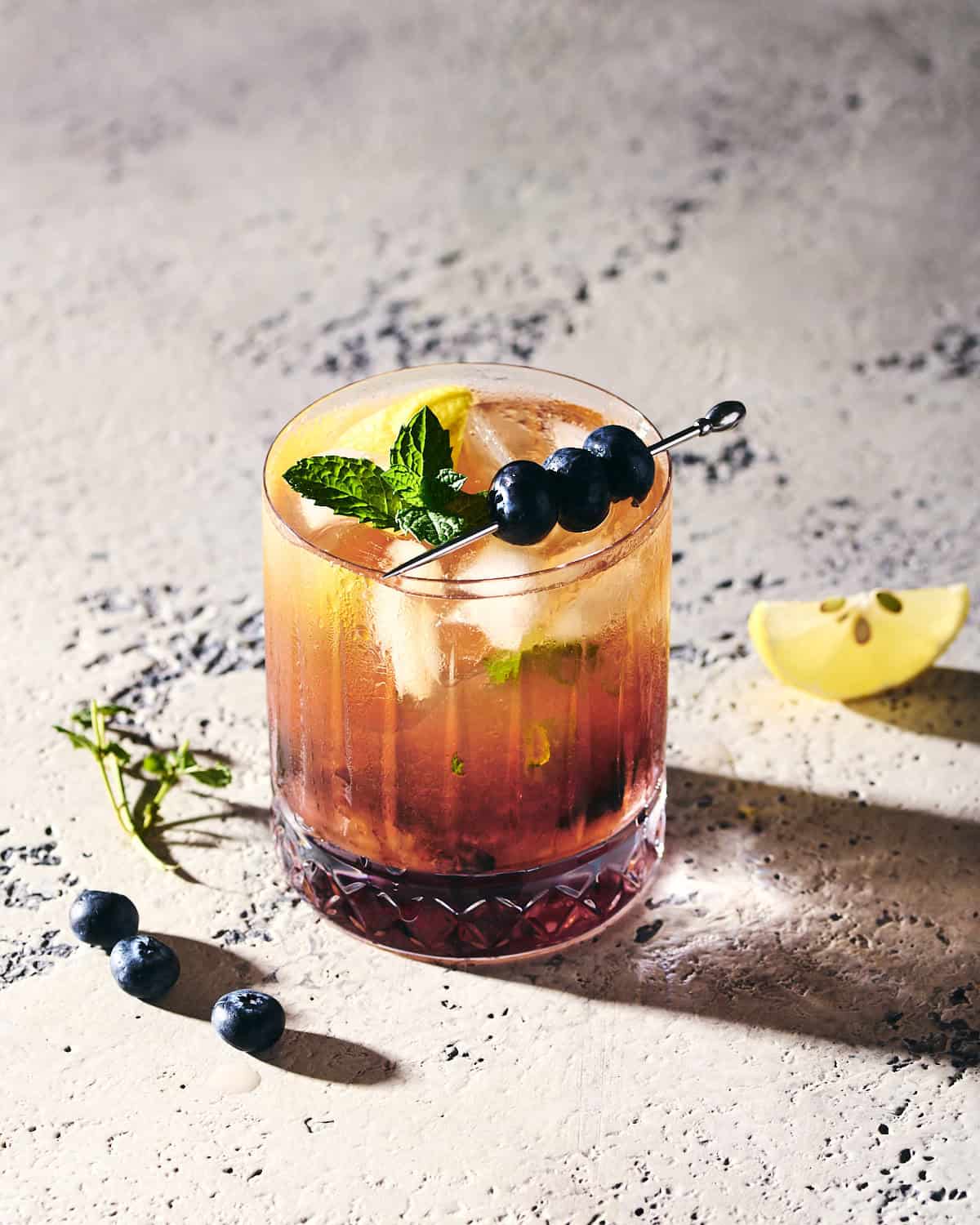 Blueberry Bourbon Smash cocktail in a glass.
